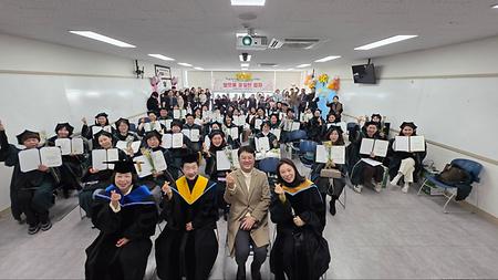 22학번 학우분들과 가족분들, 교수님들이 카메라를 바라보며 웃고 있는 사진